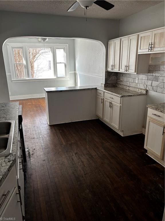 kitchen featuring white cabinetry, decorative backsplash, dark hardwood / wood-style floors, and a textured ceiling