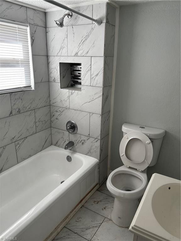 full bathroom featuring sink, shower / washtub combination, toilet, and a textured ceiling