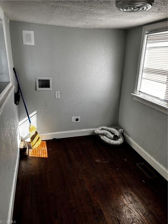 clothes washing area featuring electric dryer hookup, hardwood / wood-style floors, hookup for a washing machine, and a textured ceiling