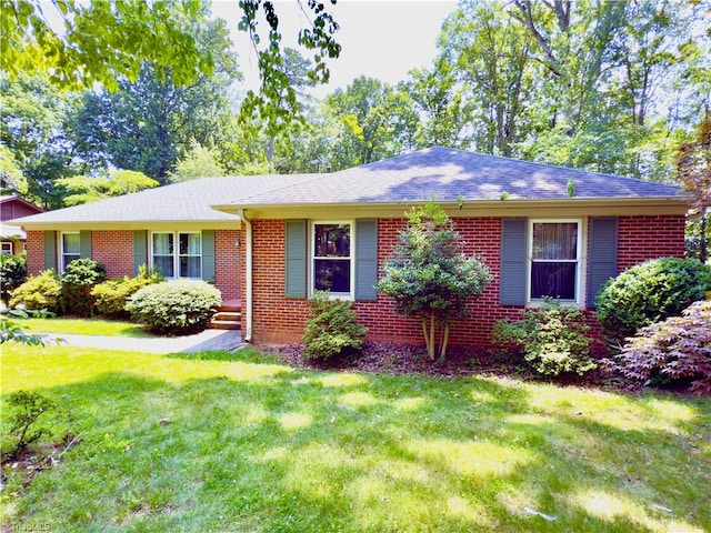 1108 Monticello St, Greensboro, NC 27410 - ranch-style house with brick siding, a front lawn, and a shingled roof