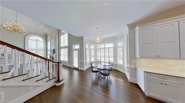 entryway featuring dark wood-style flooring, ornamental molding, and plenty of natural light