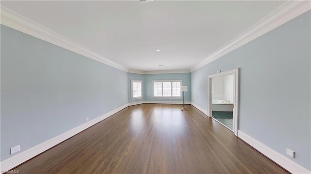 empty room featuring crown molding, wood finished floors, and baseboards