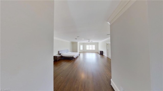 bedroom featuring dark wood-type flooring, baseboards, and ornamental molding