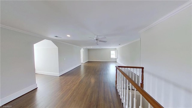 spare room featuring dark wood-style flooring, baseboards, a ceiling fan, and crown molding