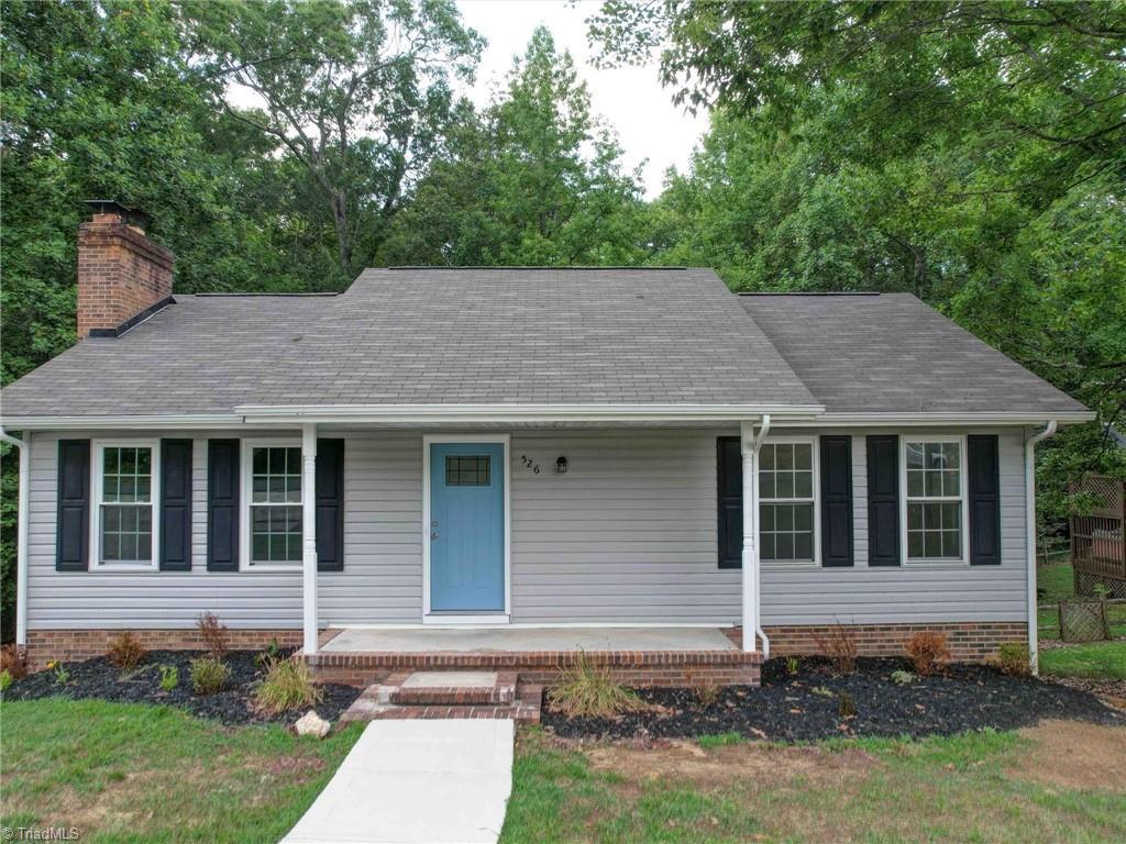 ranch-style home with a chimney and a porch