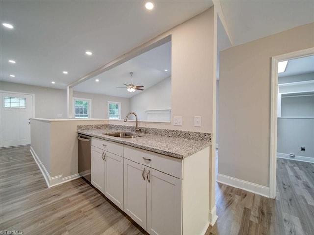 kitchen with kitchen peninsula, sink, ceiling fan, and light wood-type flooring