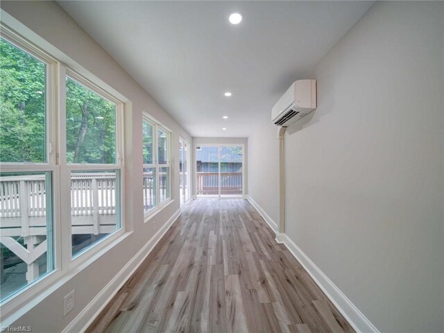 corridor featuring an AC wall unit and light hardwood / wood-style floors