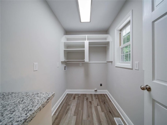 laundry area with wood-type flooring, hookup for an electric dryer, and washer hookup