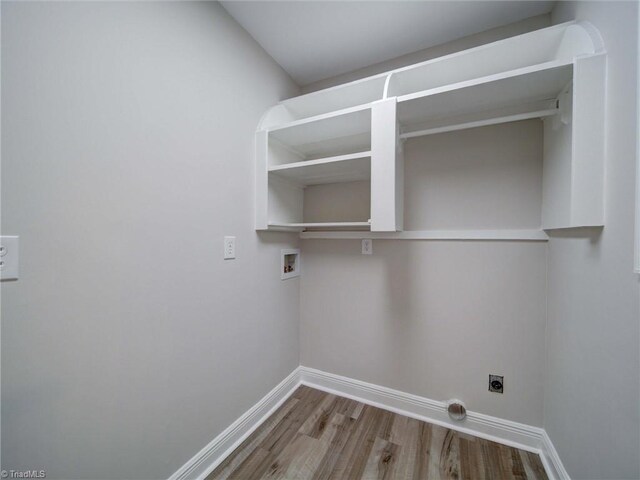 washroom with hookup for an electric dryer, hardwood / wood-style flooring, and hookup for a washing machine