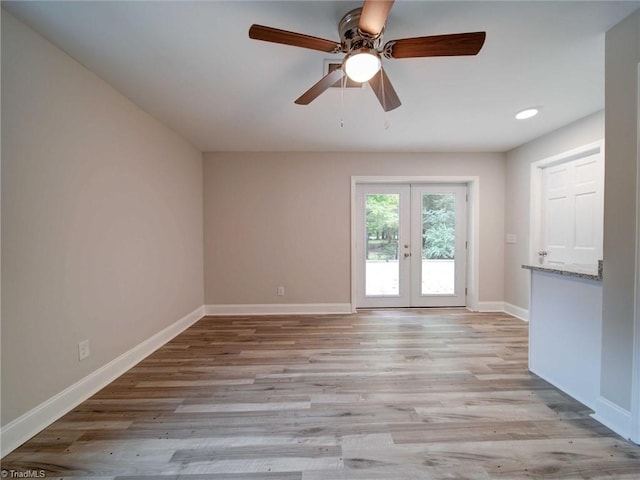 empty room featuring french doors, light hardwood / wood-style flooring, and ceiling fan