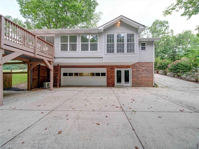 exterior space featuring a garage, a wooden deck, and central AC