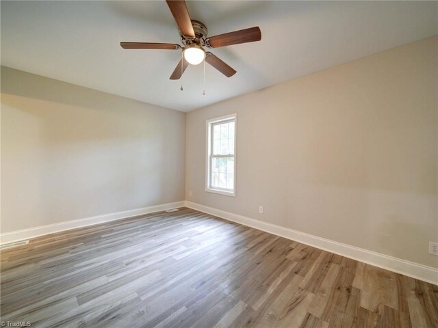 empty room featuring light wood-type flooring and ceiling fan