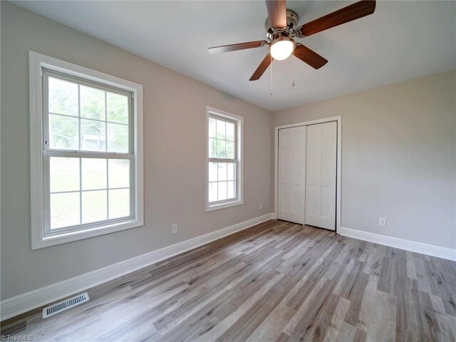 unfurnished bedroom featuring light hardwood / wood-style flooring, a closet, and ceiling fan