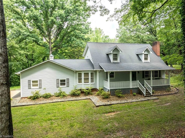 view of front facade with a porch, a chimney, a front yard, and roof with shingles