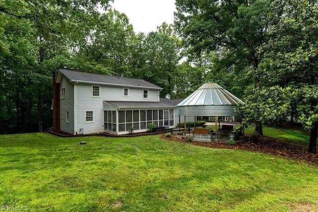 back of house with a sunroom, a yard, a patio, a gazebo, and view of scattered trees