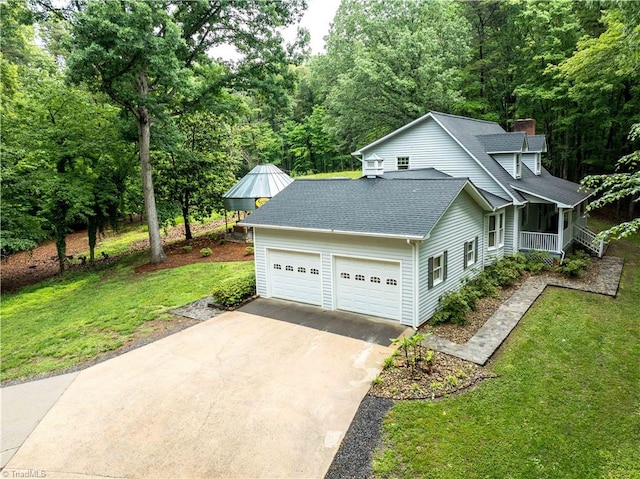 view of property exterior with roof with shingles, a yard, concrete driveway, a chimney, and an attached garage