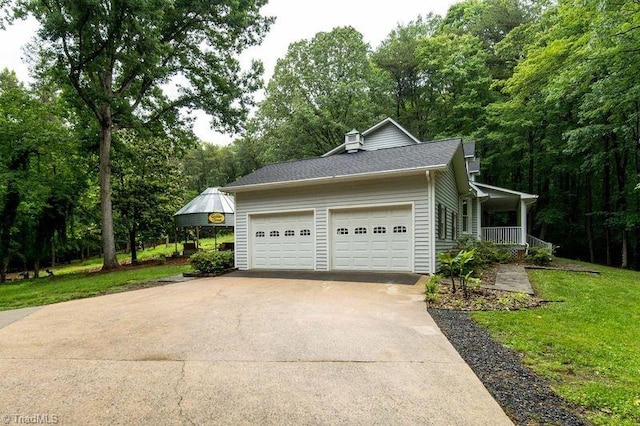 view of property exterior with an attached garage, concrete driveway, a porch, and a yard