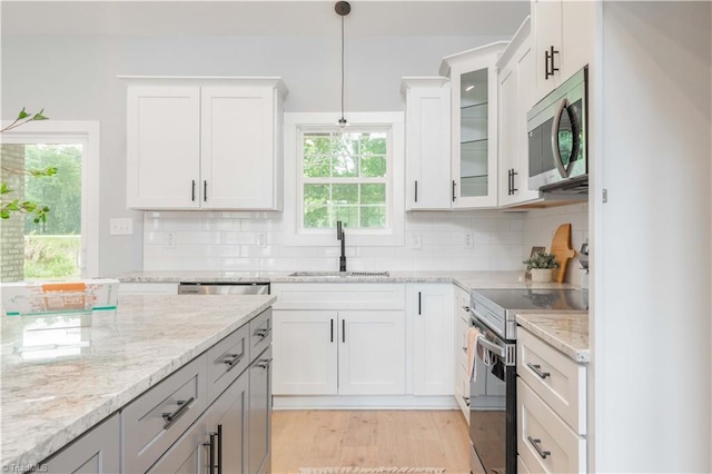 115 Corbin Ln, Lexington, NC 27295 - kitchen with appliances with stainless steel finishes, tasteful backsplash, light stone counters, pendant lighting, and glass insert cabinets