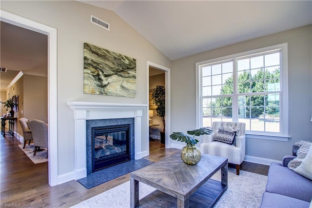 living room featuring crown molding, hardwood / wood-style floors, and lofted ceiling