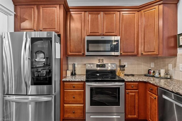 3615 Sainsbury Ln, Greensboro, NC 27409 - kitchen with stainless steel appliances, light stone countertops, backsplash, and brown cabinets