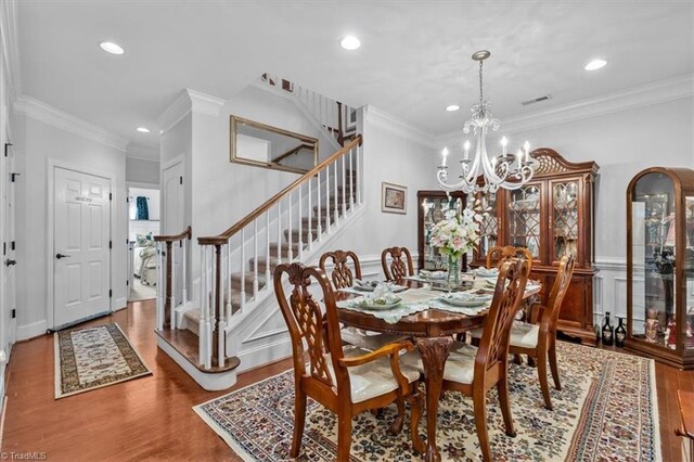 3615 Sainsbury Ln, Greensboro, NC 27409 - dining room featuring stairs, ornamental molding, wood finished floors, a chandelier, and recessed lighting