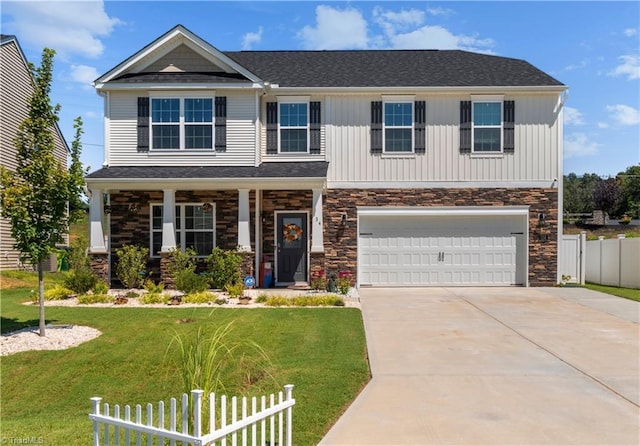 craftsman inspired home with concrete driveway, fence, a front yard, and a garage