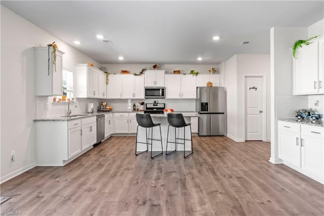 kitchen with a sink, stainless steel appliances, recessed lighting, tasteful backsplash, and visible vents