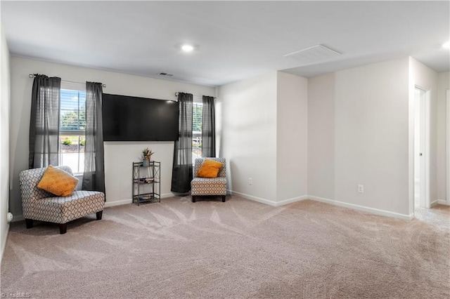 living area with carpet floors, baseboards, and visible vents