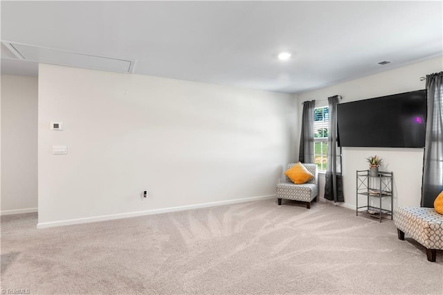 sitting room featuring baseboards, attic access, and carpet flooring