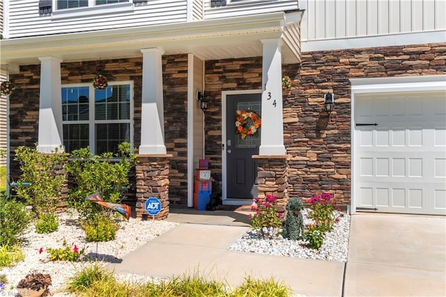 doorway to property featuring board and batten siding, covered porch, and stone siding