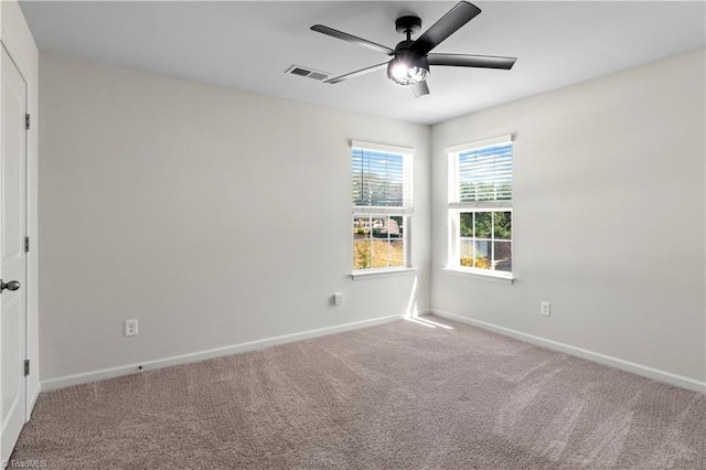 unfurnished room with baseboards, carpet, a ceiling fan, and visible vents