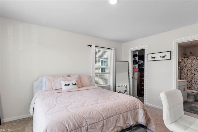 bedroom with carpet floors, baseboards, a closet, a spacious closet, and ensuite bathroom