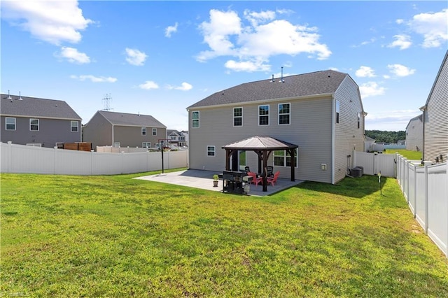 rear view of house with a fenced backyard, a gazebo, a yard, and a patio area