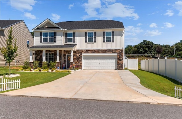 view of front facade with fence, covered porch, an attached garage, and a front lawn