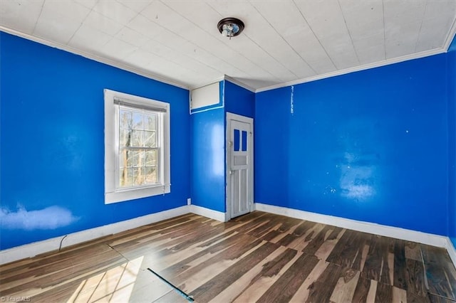 unfurnished room featuring ornamental molding, baseboards, and wood finished floors