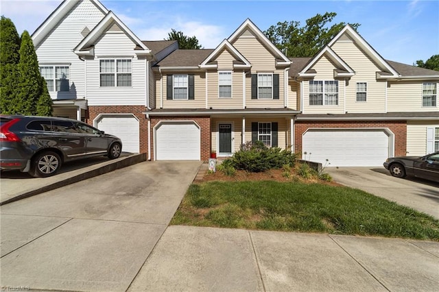 view of property featuring an attached garage, driveway, and brick siding