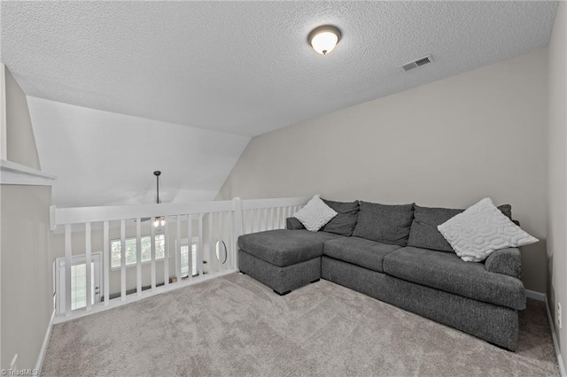 carpeted living area featuring a textured ceiling and vaulted ceiling