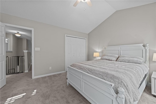 bedroom with light colored carpet, vaulted ceiling, a closet, a ceiling fan, and baseboards