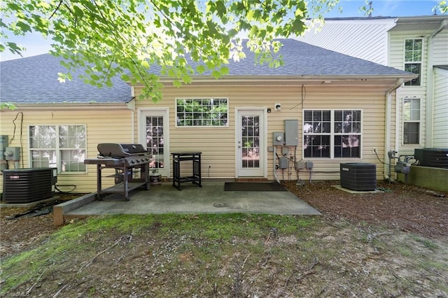 rear view of property with central AC, a patio, and roof with shingles