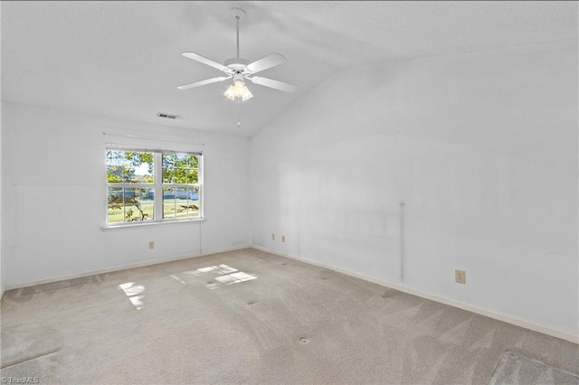 spare room featuring ceiling fan, light carpet, and vaulted ceiling