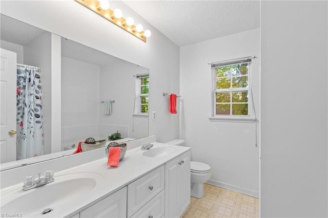 bathroom with toilet, a shower with curtain, vanity, and a textured ceiling