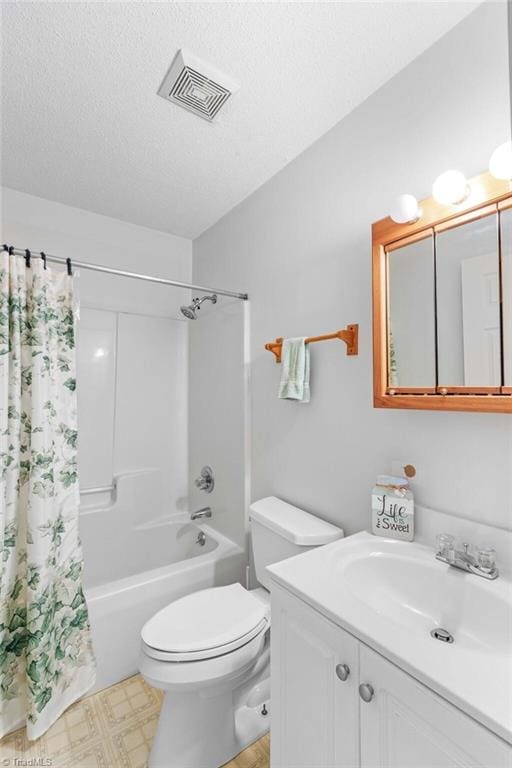 full bathroom with shower / bath combo, vanity, toilet, and a textured ceiling