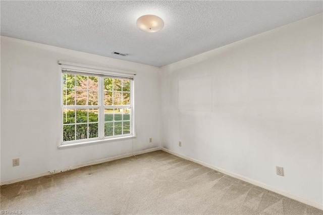 carpeted empty room featuring a textured ceiling