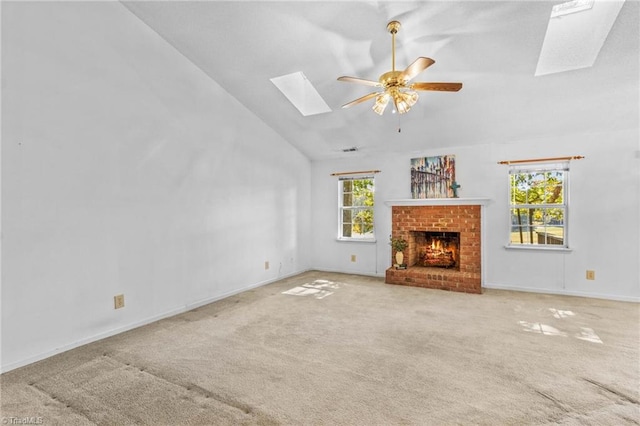 unfurnished living room with a fireplace, a wealth of natural light, ceiling fan, and a skylight