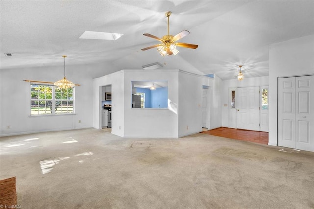 unfurnished living room with ceiling fan, light carpet, and lofted ceiling with skylight