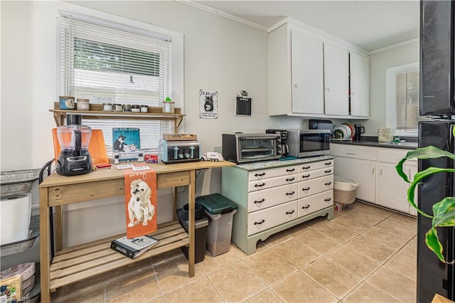 1602 Larkin St, High Point, NC 27262 - kitchen featuring ornamental molding, white cabinets, stainless steel microwave, and light tile patterned floors