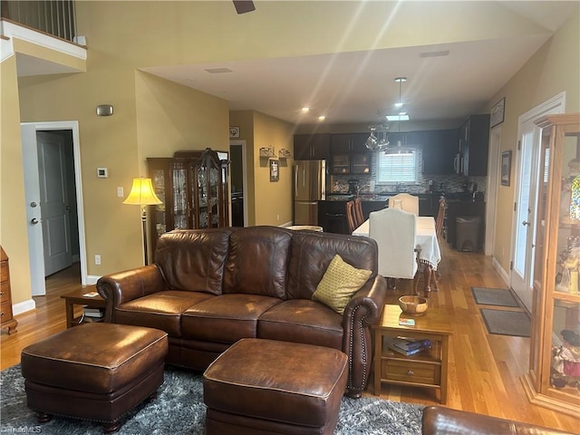 living room with wood finished floors, visible vents, and baseboards