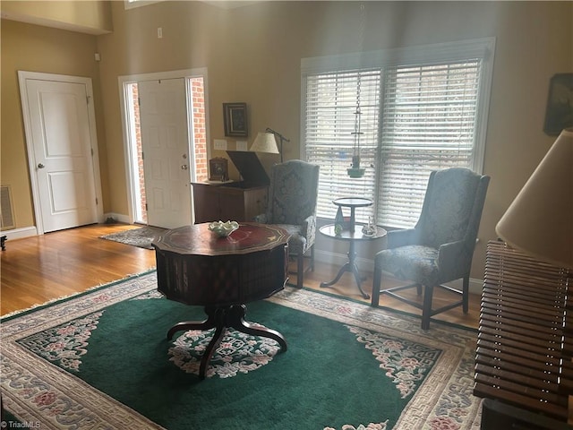 foyer entrance featuring visible vents, baseboards, and wood finished floors