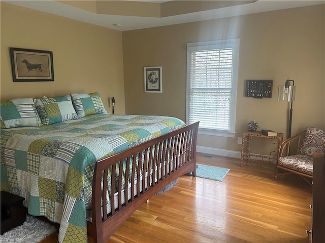 bedroom featuring baseboards and wood finished floors