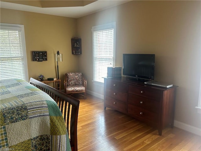 bedroom with baseboards and light wood finished floors